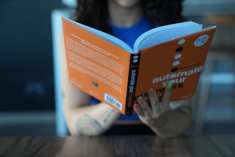 Uma Mulher Sentada Em Uma Mesa Lendo Um Livro TuvtIxLuA3I