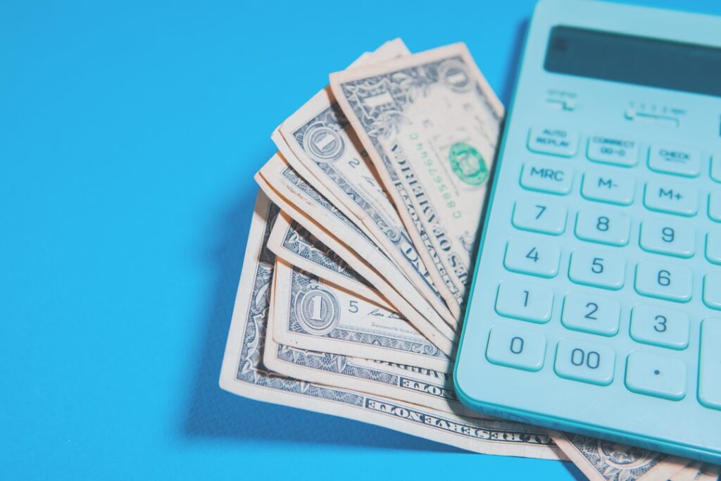 Notas De Dolar Americano E Uma Calculadora Em Fundo Azul y1vS_aBALGc