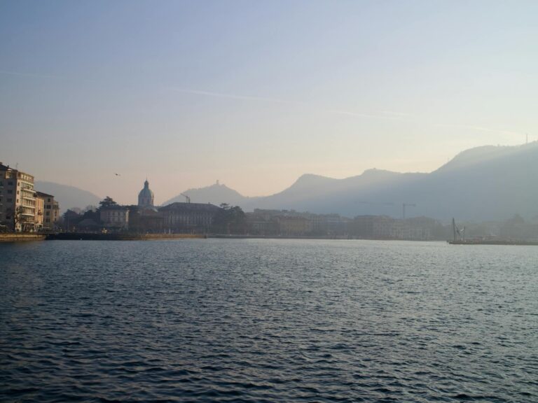 Peaceful sunset over Como, Italy, with lake and city skyline.