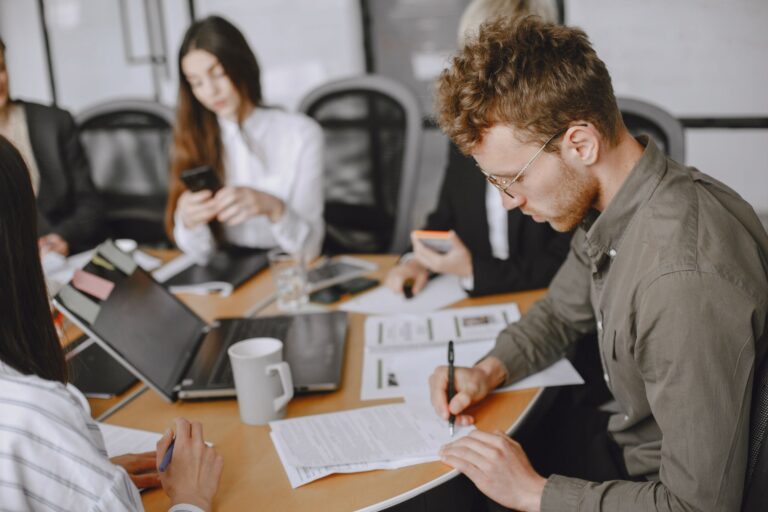Business professionals engaged in a corporate meeting, emphasizing document signing and collaboration.